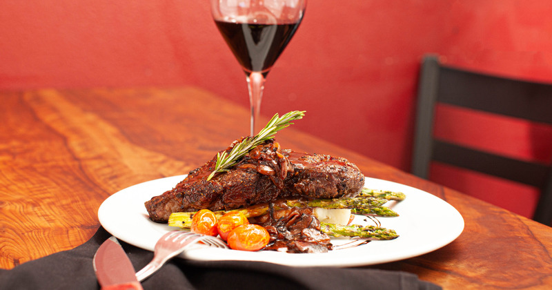 New York steak over grilled asparagus