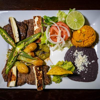 Carne Asada plate with rice, beans, side salad, grilled cactus, queso fresco, guacamole.