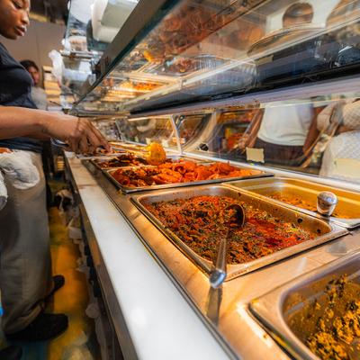 Nigerian cuisine buffet-style with jollof rice, stews, and meats.