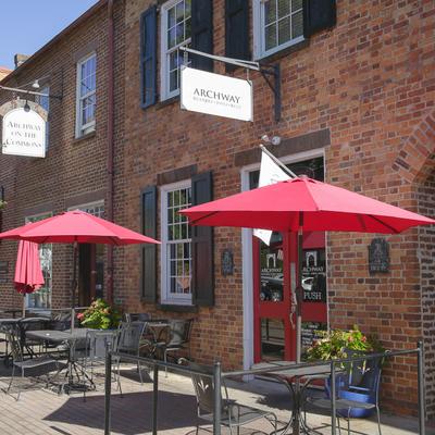 Tables, chairs, and parasols outside.