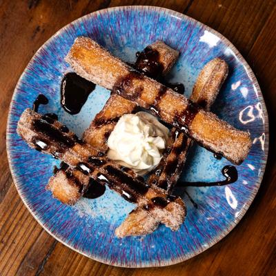 Churros drizzled with Chipotle Chocolate and House Made whipped cream at 13 Tacos & Taps.