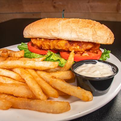 Cod Sandwich with lettuce, tomato, side of fries and a dip.