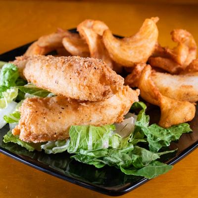 Fish & Chips served over lettuce on a black plate.