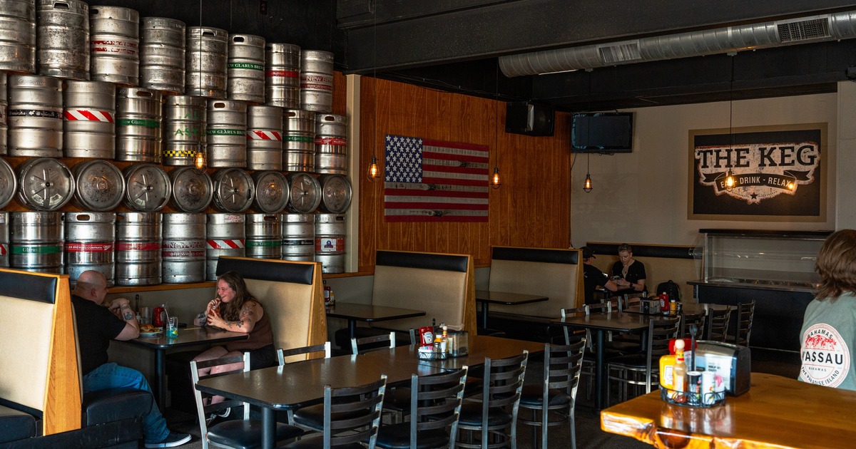 Interior, dining area with decorative kegs in the wall, benches, chairs and tables