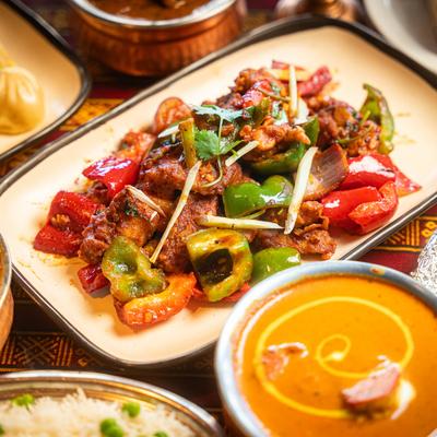 Chili Curry Chicken, Paneer Tikka Masala, and other assorted dishes on a table.