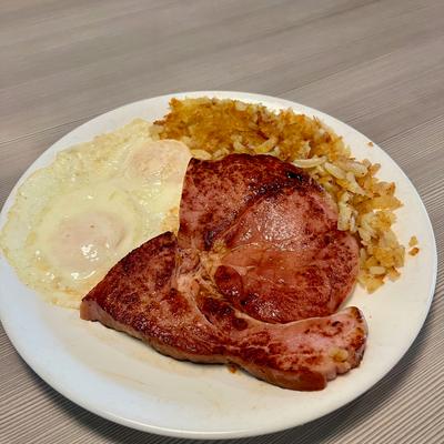 Plate of ham steak, eggs and hash browns.