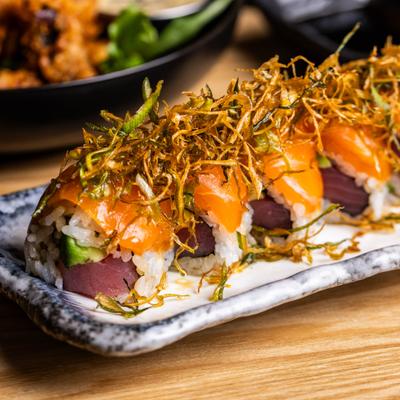 Truffle salmon sushi rolls topped with fried leeks.