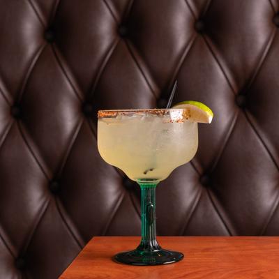 Margarita cocktail served in a rimmed glass, garnished with lime wedge.