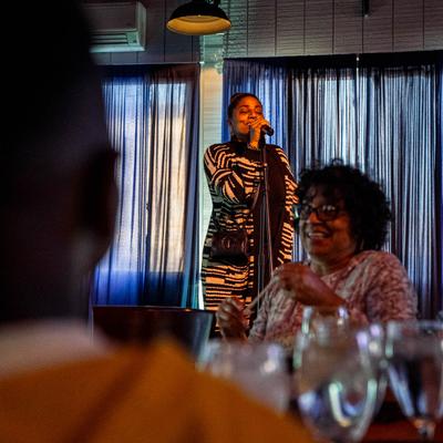Interior, a singer performing on a stage, guests sitting at tables