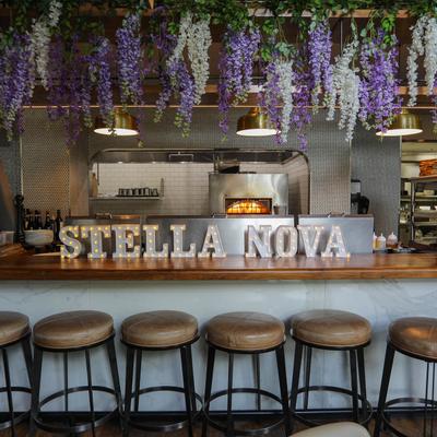 Food counter with bar chairs, Stella Nova letters and artificial wisteria decoration.