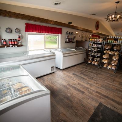 Shop interior featuring chest freezers, wooden flooring, and display racks.