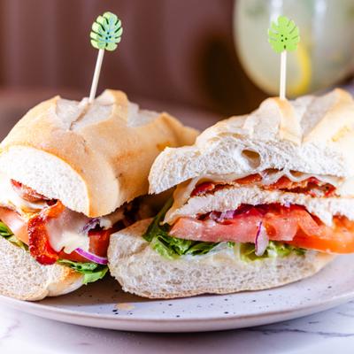 Grilled chicken sandwich with lettuce, tomato, melted cheese and red onions.