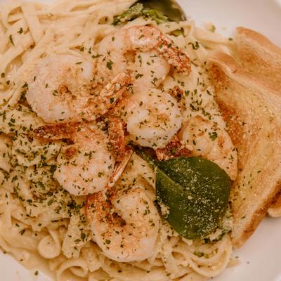 Creamy shrimp pasta with herbs and toast.