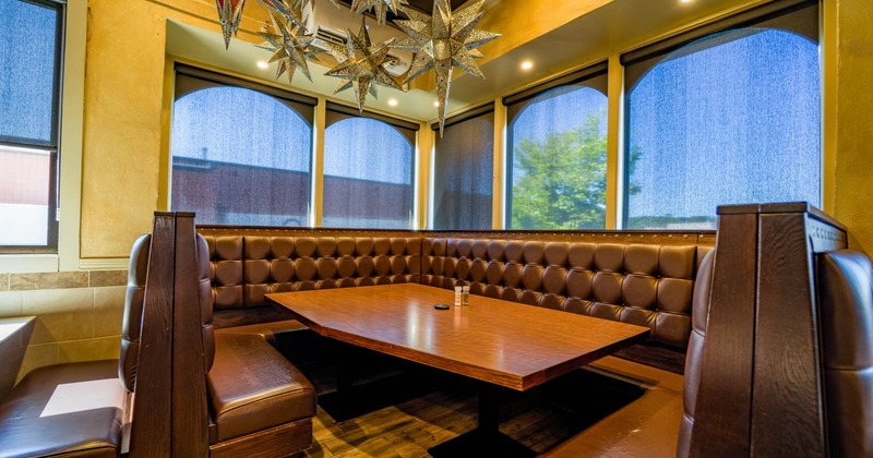 Restaurant booth with tufted leather seats and a large wooden table