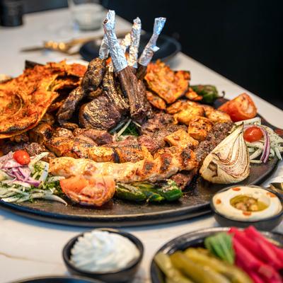 Mixed grill platter accompanied with veggies and conidments.