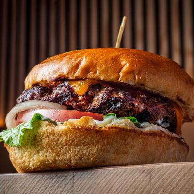 Cheeseburger with lettuce, tomato, and onions.