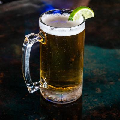 A pint of beer garnished with a lime wedge.