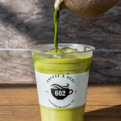 Matcha latte being poured in a cup.