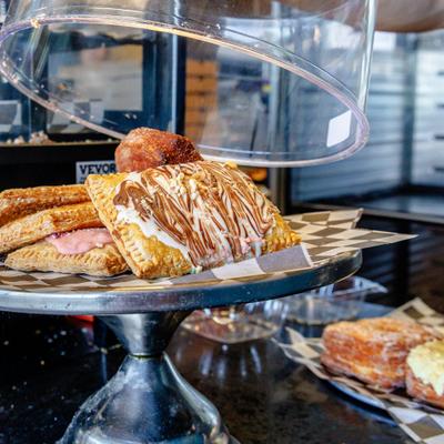 Assorted gourmet pastries, including glazed pop-tarts and custard-filled items.