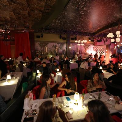 Full room of people having dinner, every table is seated.