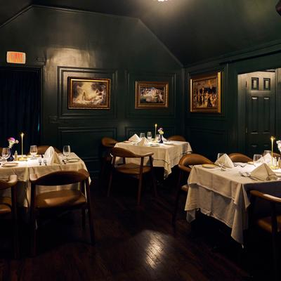 Intimate restaurant seating beneath framed artwork.