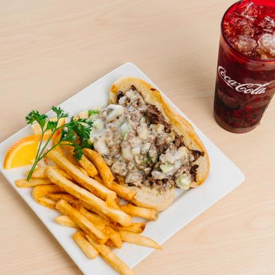 Philly cheesesteak sandwich with fries and soft drinks.