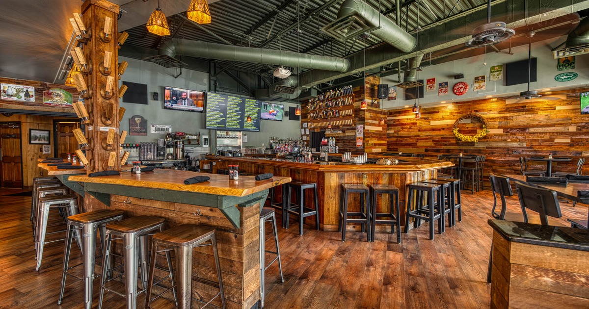 Interior, high tables and chairs, bar in the back