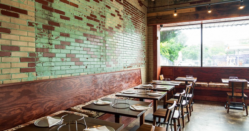 Interior, banquette seating by a wall with tables and chairs