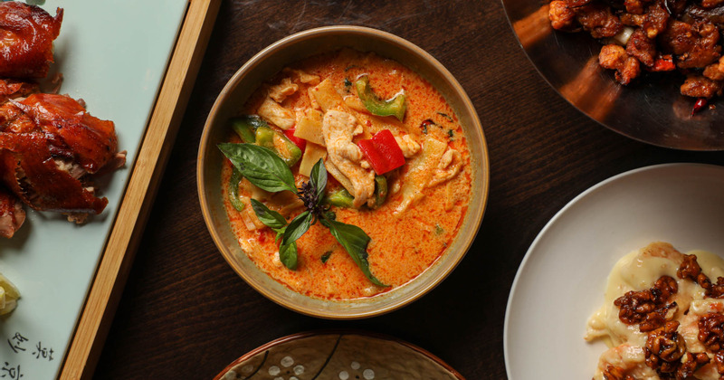 Red curry bowl, top view, accompanied by different dishes