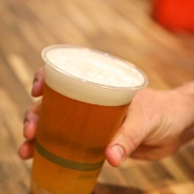 A hand holding a glass of beef.