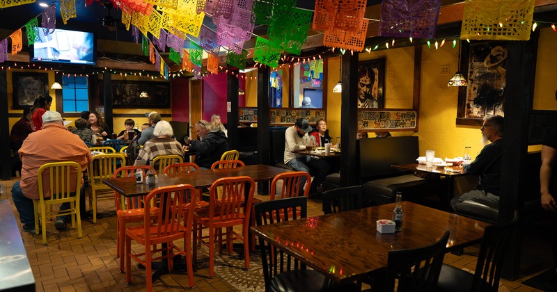 Cozy Mexican-style interior dining area with guests enjoying their food and drinks