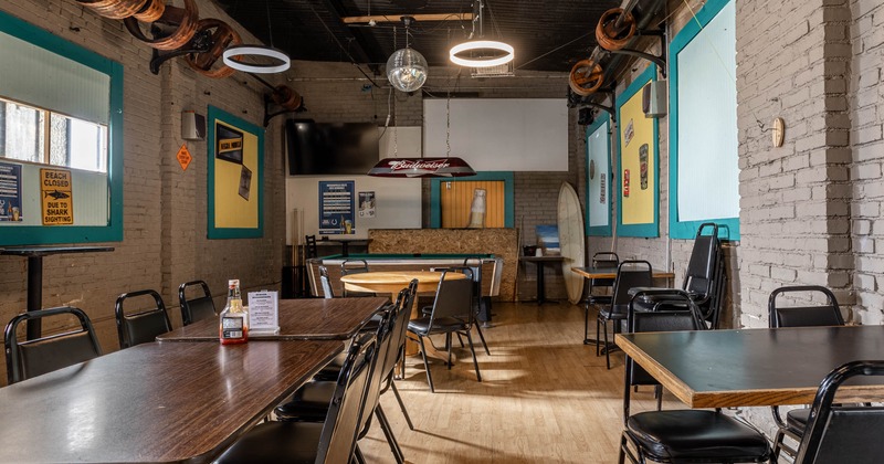 Interior seating area with wooden tables and metal chairs