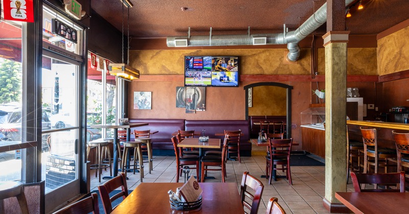 Casual restaurant interior with wooden tables, chairs, and bar stools