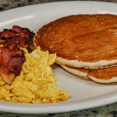 Pancakes with scrambled eggs and bacon.