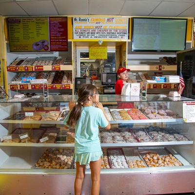 A customer stands at a bakery case filled with a variety of pastries.