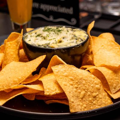 Plate of nachos served with Spinach Dip.
