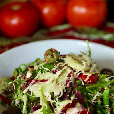Mixed green salad topped with shredded vegetables.