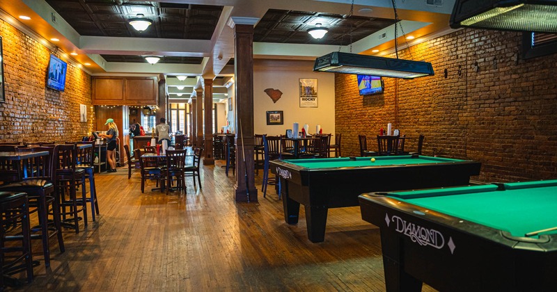 A wide view of the interior, the part with the pool tables, the dining room behind