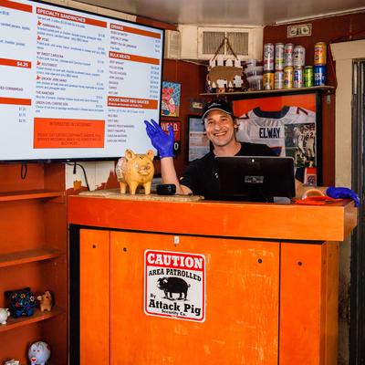 Interior, a staffer by the front desk with merchandise shelves and wall menus