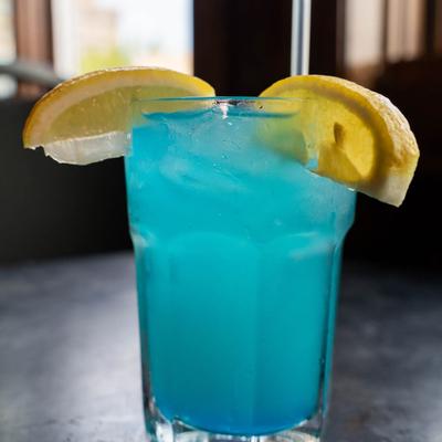 Glass of Blue Hawaiian, garnished with lemon slices.