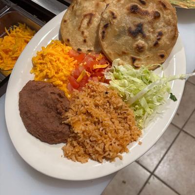 Corn tortillas served with refried beans, lettuce, diced tomatoes and rice.