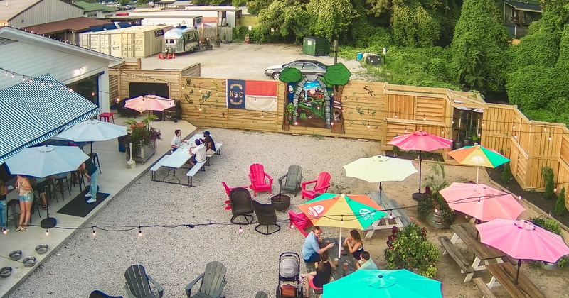 Arial photo of garden with fire pit and tables and chairs, wide view