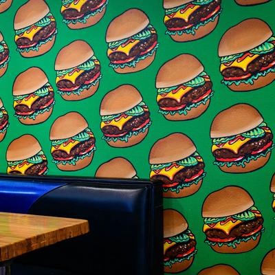 Dining area wall with painted burgers on it.