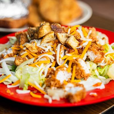 Crispy fried chicken salad with lettuce, cheese, and croutons.