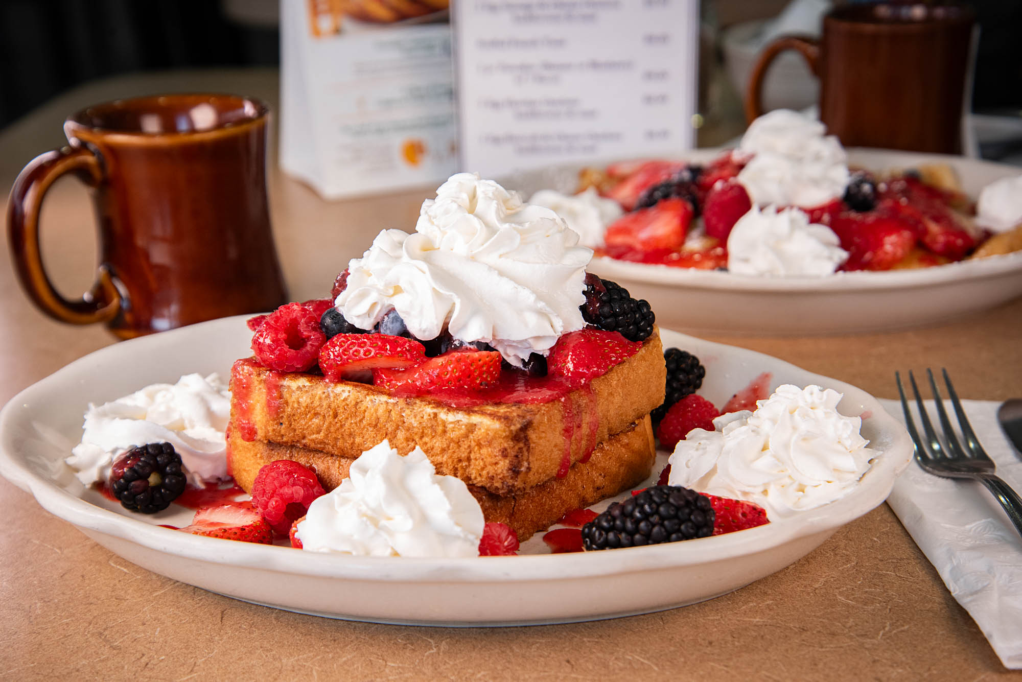 French Toast topped with whipped cream and fresh berries