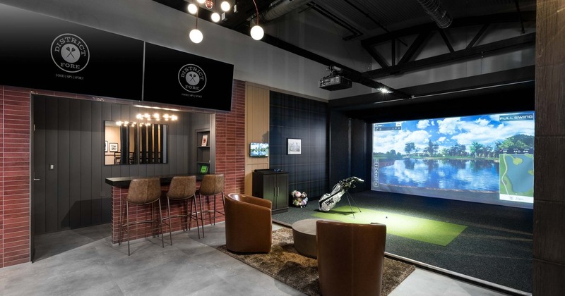 A space with seating and a golf simulator