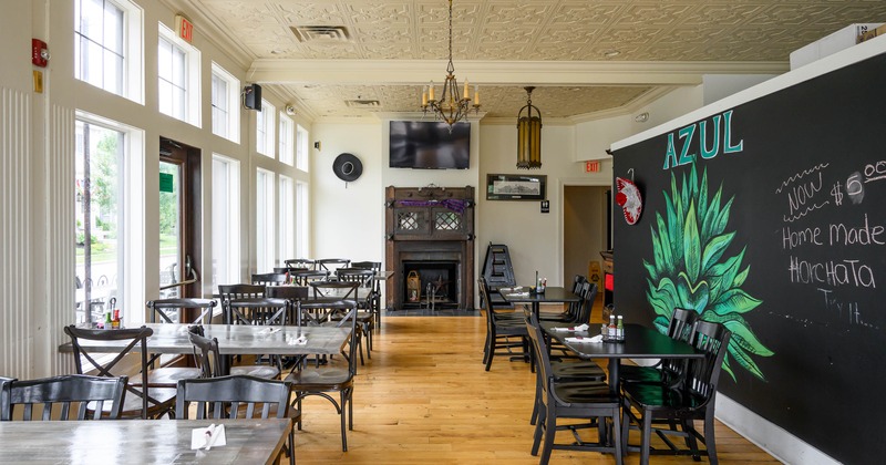 Interior of the restaurant featuring wooden floors, black tables and chairs