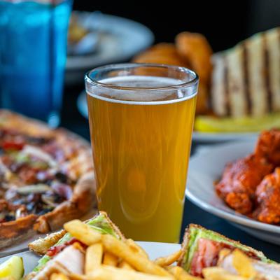 Glass of beer served on the table with food.