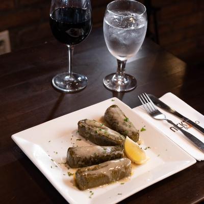 Stuffed grape leaves served with wine.