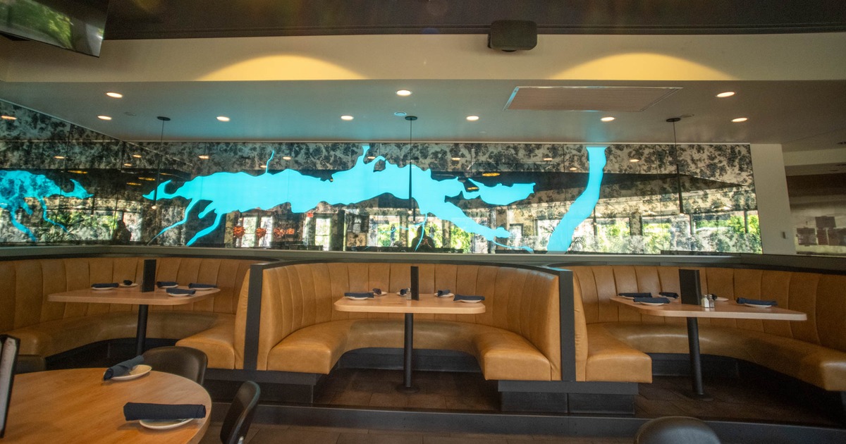 Interior with leather booths, set tables, and a vibrant blue map